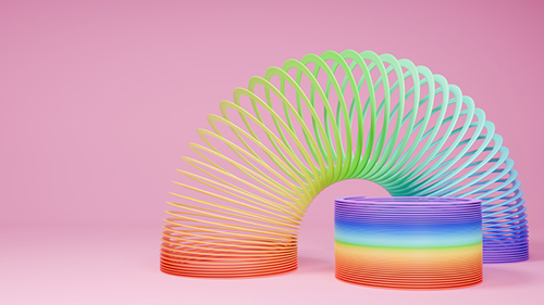 Slinky toys on pink background. Rainbow spring. 3D rendering